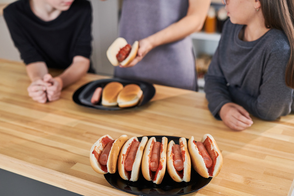 Woman Cooks Hot Dogs with Her Children